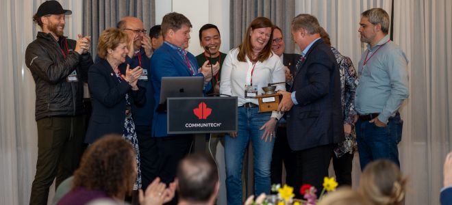Communitech CEO Chris Albinson and Board Chair Catherine Graham present the inaugural Community Grinder award to OpenText Board Chair Tom Jenkins.