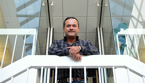 Flavio Gomes, CEO of LogiSense, gazes out of the balcony of an office building.