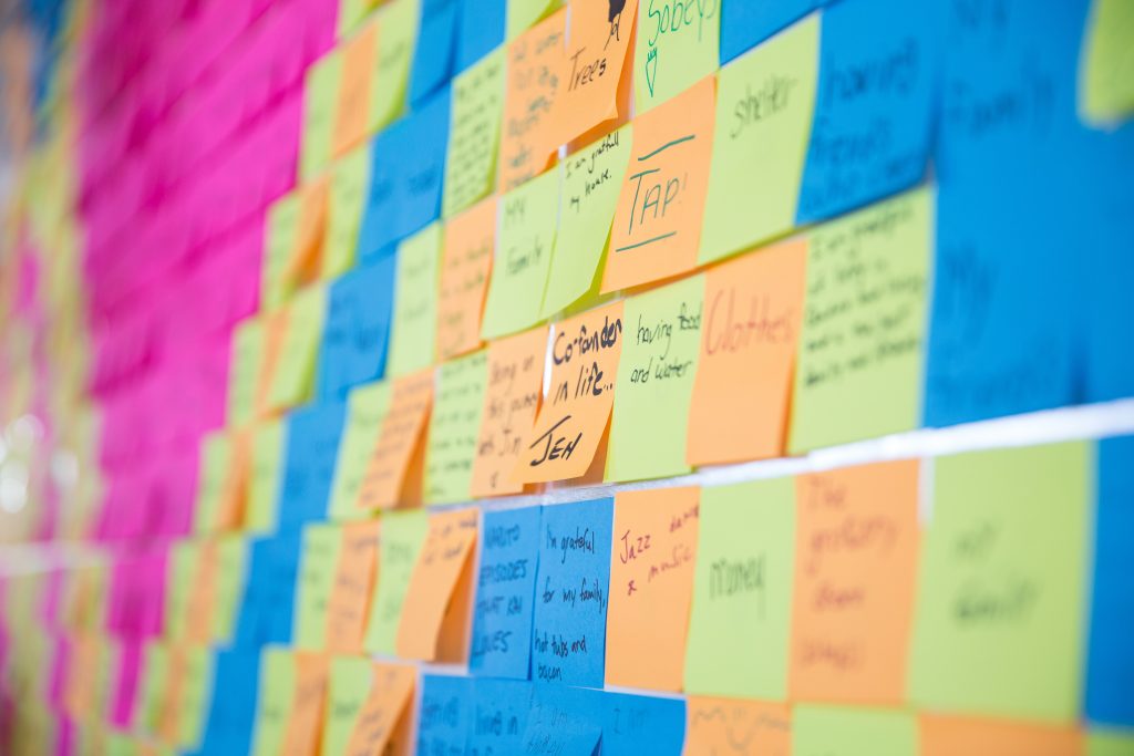 A wall covered in different coloured sticky notes, also known as Plasticity's Gratitude Wall