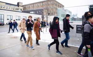 Students walking on the sidewalk between the Tannery and Deloitte