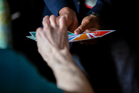 Attendee drawing a card from a colourful hand of cards
