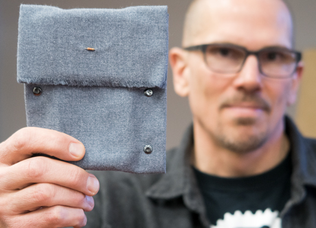Marcel O'Gorman holding up a Resistor Case, a pouch for your phone.